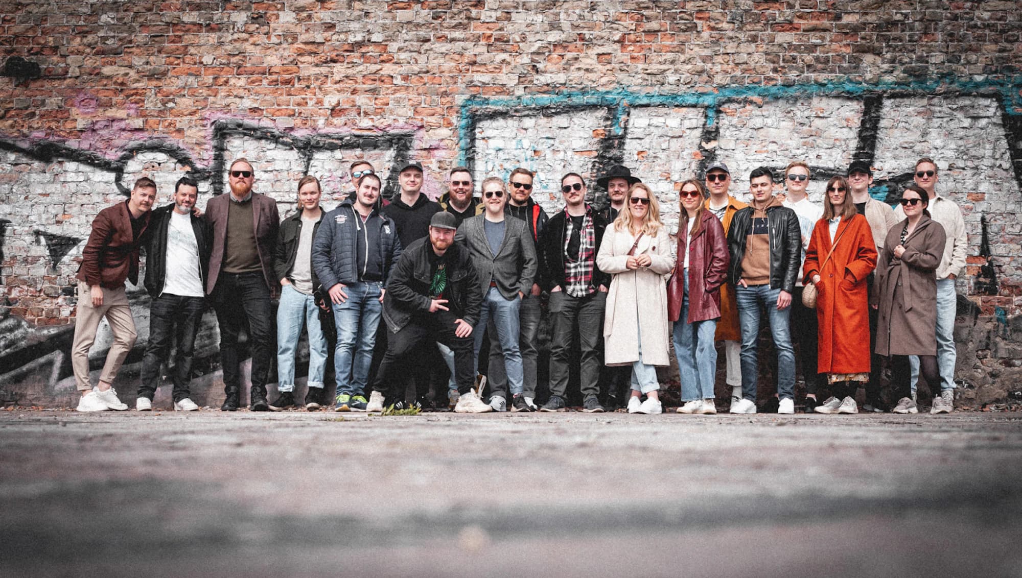 All of Kumpan in front of a brick wall in Riga